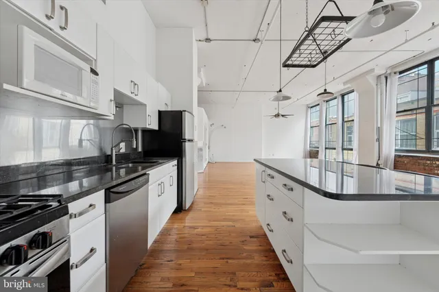 a large kitchen with cabinets and stainless steel appliances