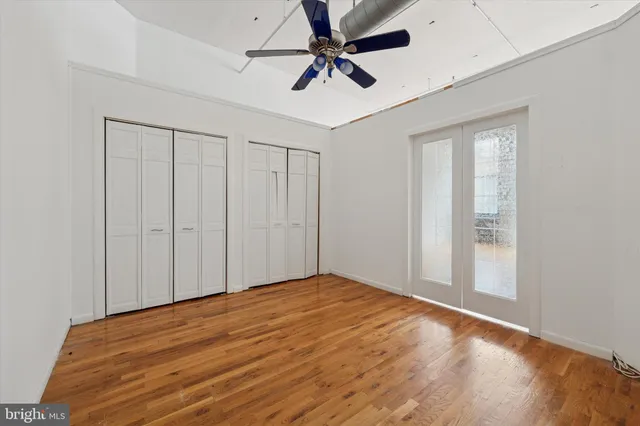a view of empty room with window and ceiling fan