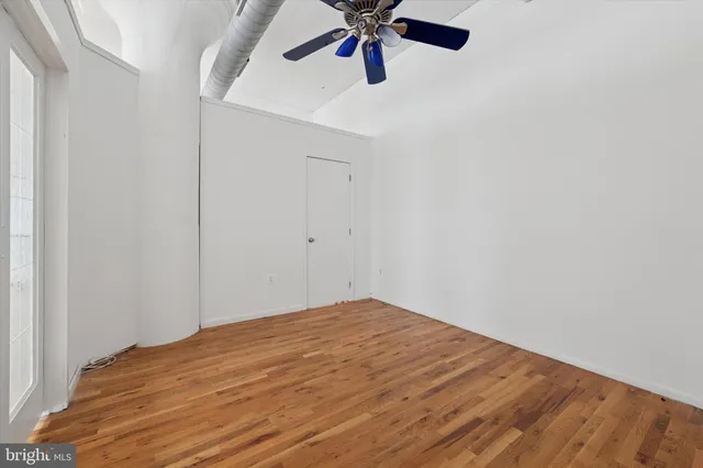 a view of empty room with wooden floor