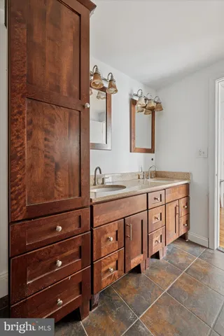 a spacious bathroom with a granite countertop sink and a mirror