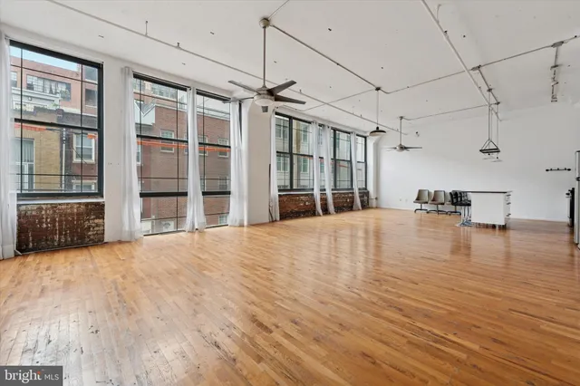 a view of empty room with wooden floor and windows