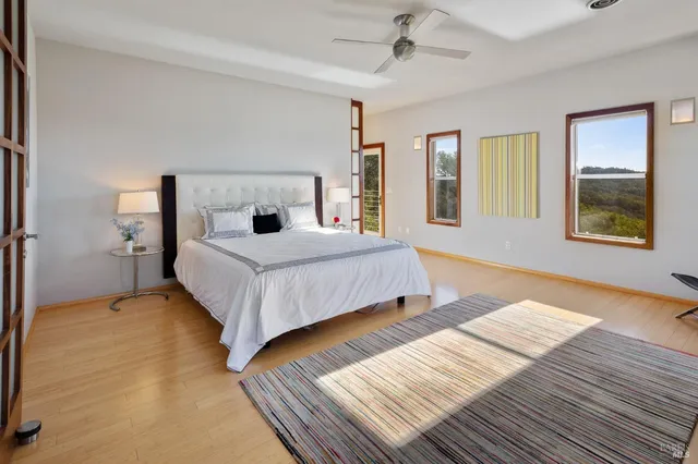 a bedroom with a bed lamp on table and a window