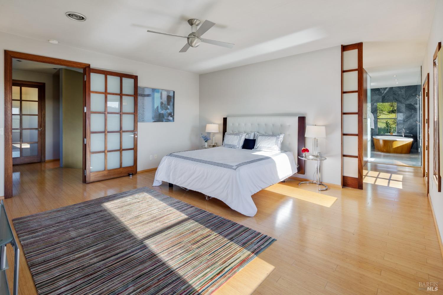 675 Shiloh Canyon Santa Rosa, CA 95403 - Photo 13 of 26 a bedroom with a large bed a chandelier and windows