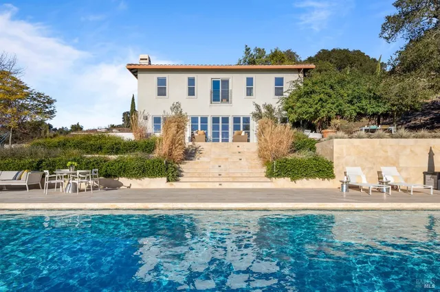 a view of a house with a yard and potted plants