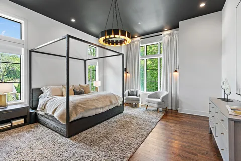 a bedroom with a large bed and a chandelier