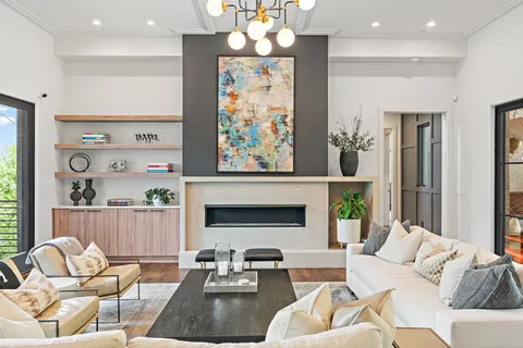 a living room with furniture a chandelier and a fireplace