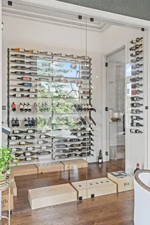 a dining room with wooden floor a chandelier a glass table and chairs