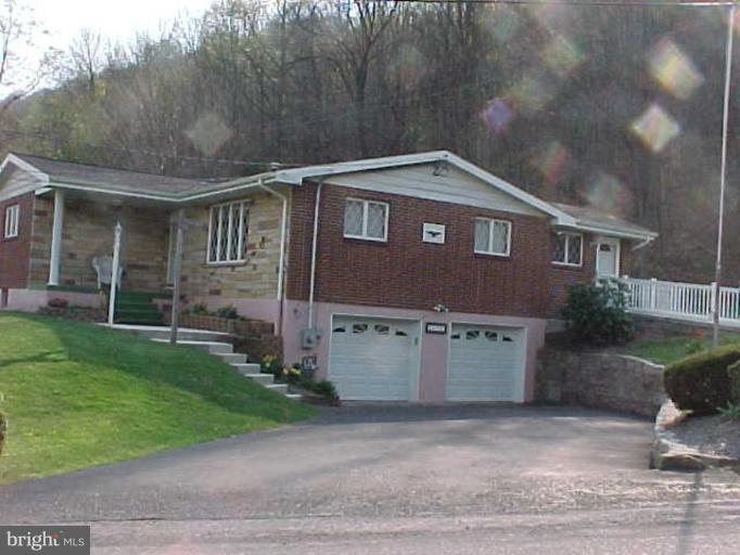 a front view of a house with a garden and plants