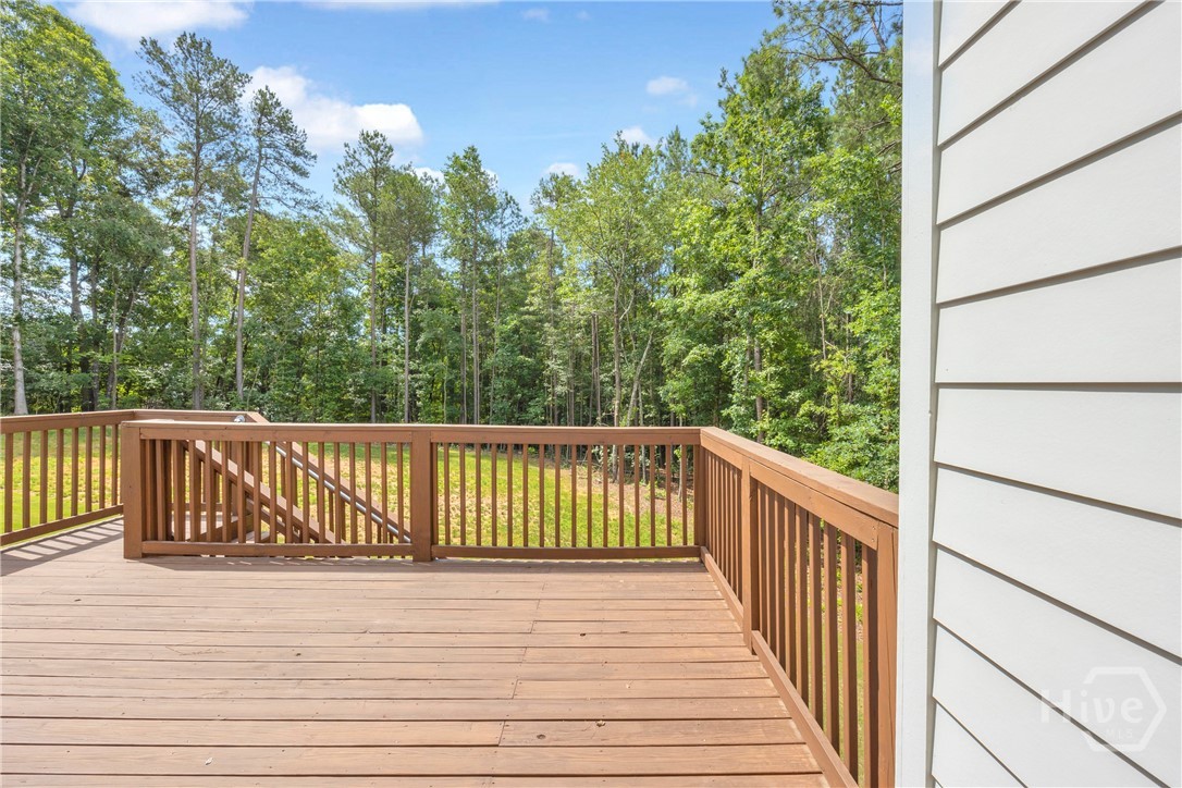 2476 St Martin Way Monroe, GA 30656 - Photo 64 of 75 Spacious outdoor deck with wood-finish flooring and railing, featuring stairs descending to a grassy area