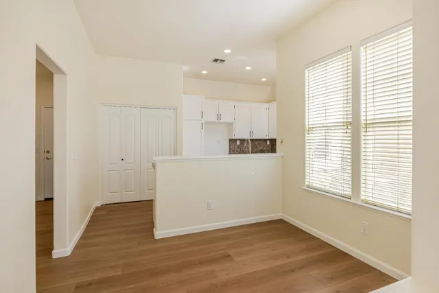 a view of a kitchen with wooden floor and windows