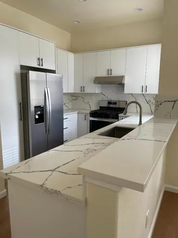 a kitchen with refrigerator a stove a sink and cabinets