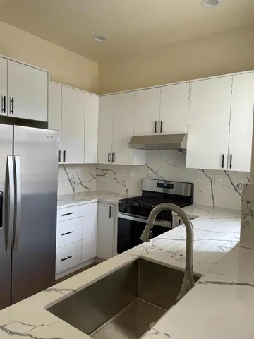 a kitchen with stainless steel appliances granite countertop a sink stove and refrigerator