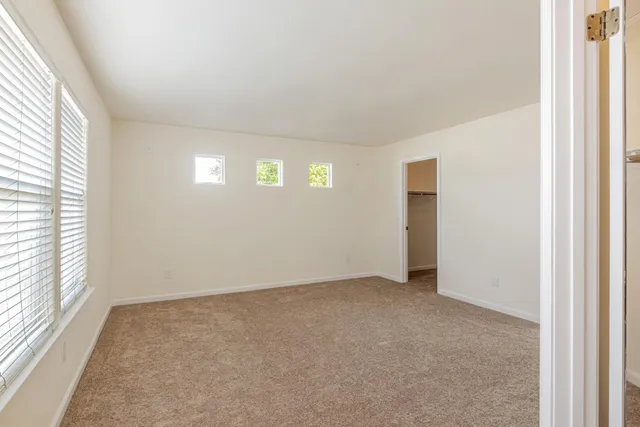 an empty room with windows and closet