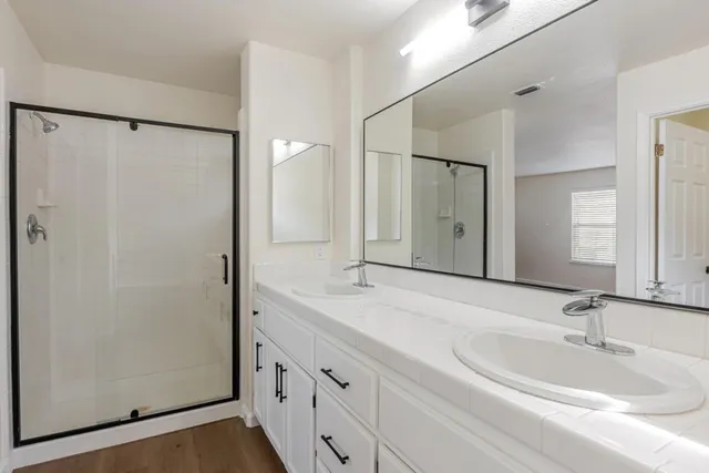a bathroom with a double vanity sink and mirror