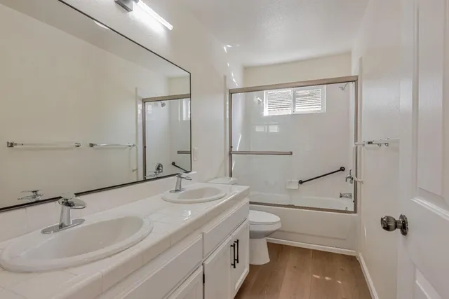 a bathroom with a granite countertop sink a toilet and shower