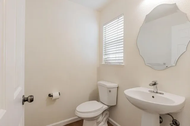 a bathroom with a sink a toilet and a mirror