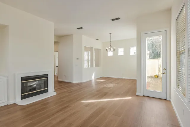 a view of empty room with wooden floor and fireplace