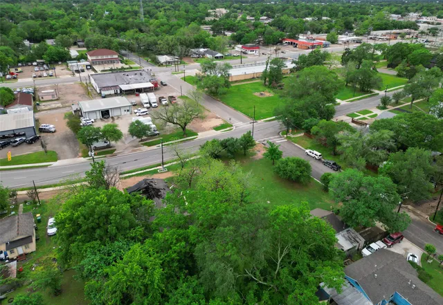 an aerial view of residential houses with outdoor space and trees