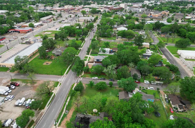 an aerial view of residential houses with outdoor space and trees