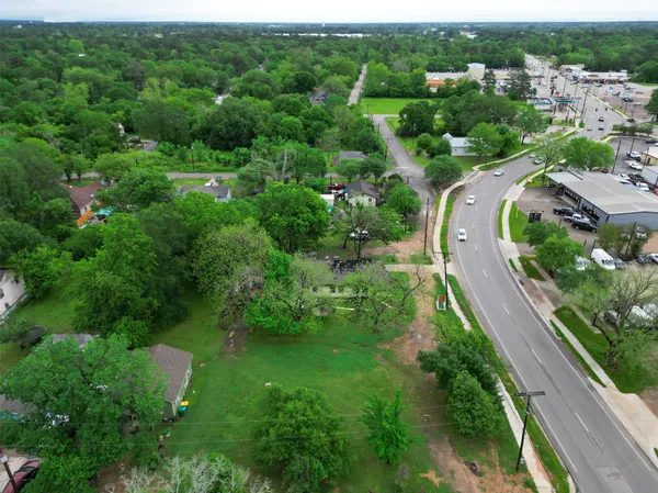 an aerial view of residential houses with outdoor space and trees