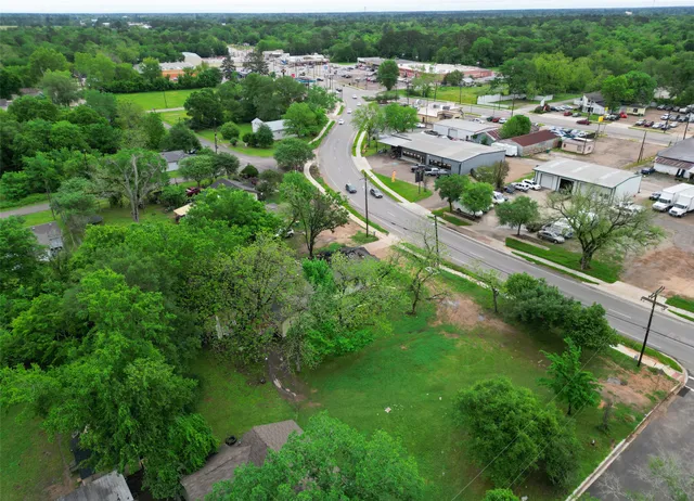 an aerial view of residential houses with outdoor space and trees