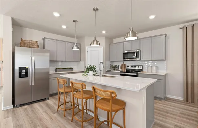 a kitchen with kitchen island a refrigerator stove microwave and cabinets