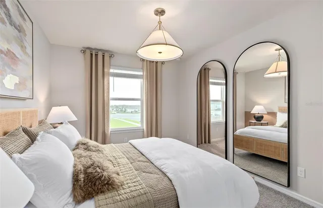 a bedroom with bed and a chandelier