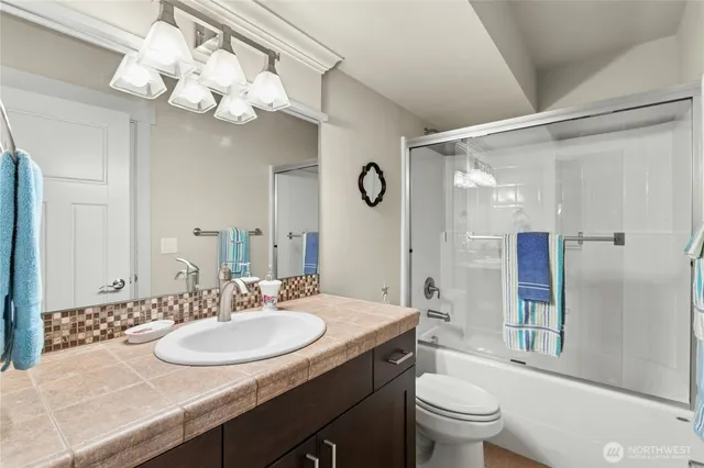 a bathroom with a granite countertop sink a toilet and a mirror