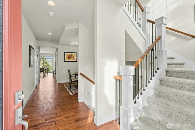 a view of staircase with lots of frames on wall and wooden floor
