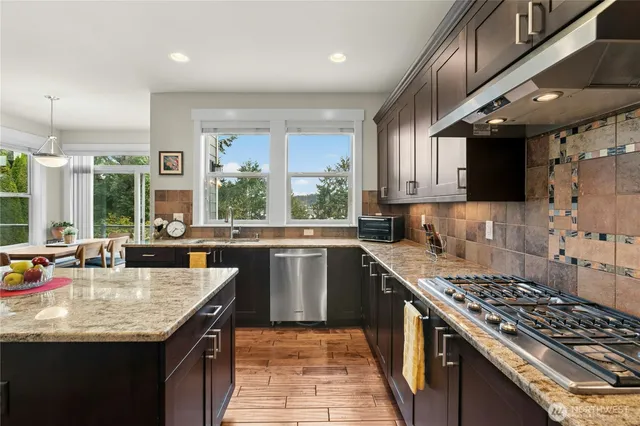 a kitchen with granite countertop a sink a counter space appliances and cabinets