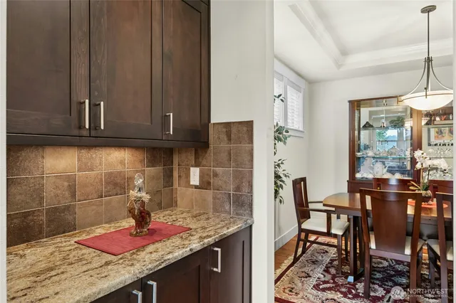 a kitchen with granite countertop cabinets and dining table in it
