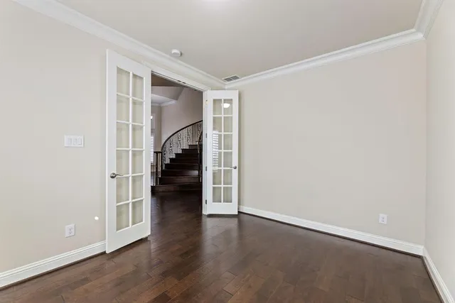 a view of empty room with wooden floor and stairs