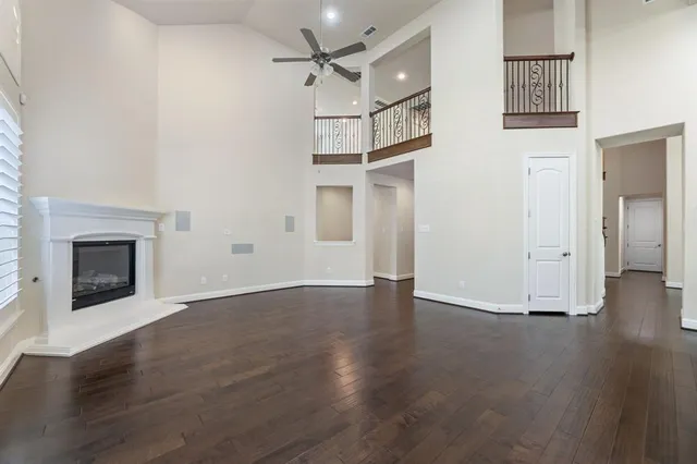 a view of empty room with wooden floor and fireplace