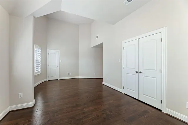 a view of an empty room with wooden floor