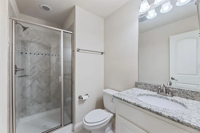a bathroom with a granite countertop sink toilet and shower
