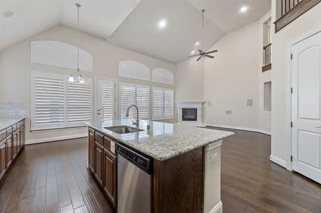 a kitchen with a sink a faucet a chandelier and wooden floor