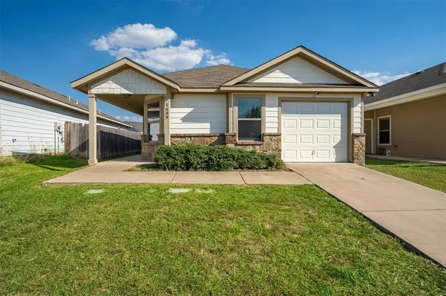 a front view of a house with a yard and garage