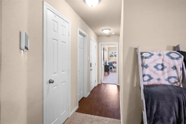 a view of a hallway with wooden floor and closet