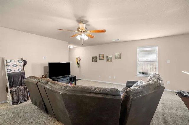 a living room with furniture a flat screen tv and a window