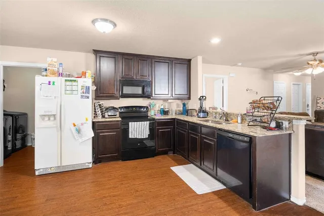 a kitchen with stainless steel appliances granite countertop a refrigerator sink and stove