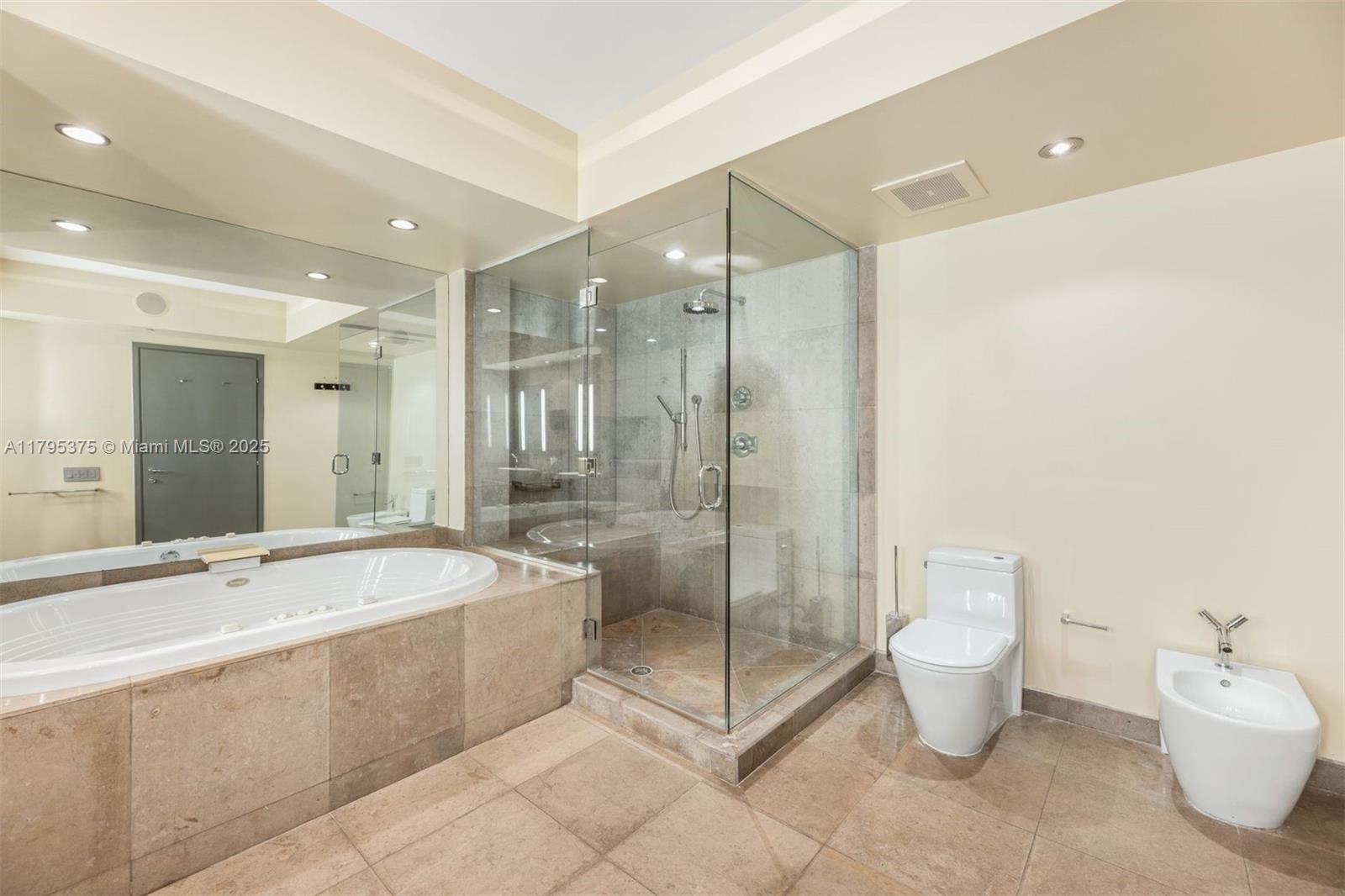 450 Alton Road, Unit 2303 Miami Beach, FL 33139 - Photo 13 of 51 a spacious bathroom with a bathtub shower sink mirror and toilet