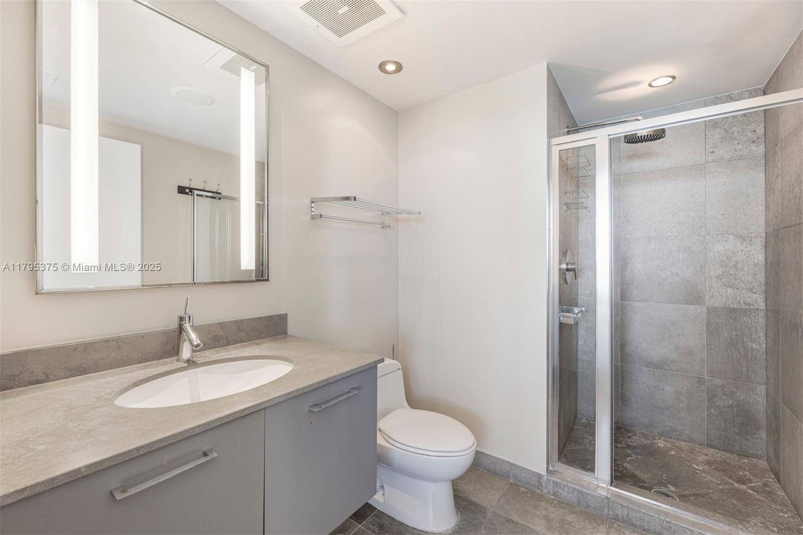 450 Alton Road, Unit 2303 Miami Beach, FL 33139 - Photo 18 of 51 a bathroom with a granite countertop sink toilet and shower