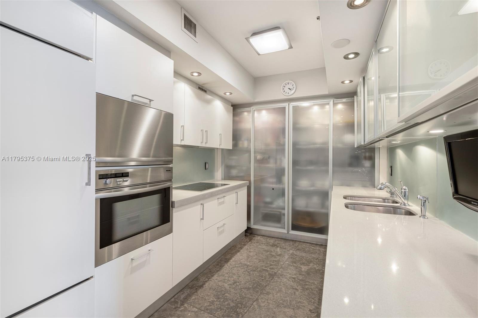 450 Alton Road, Unit 2303 Miami Beach, FL 33139 - Photo 23 of 51 a kitchen with stainless steel appliances a refrigerator sink and microwave