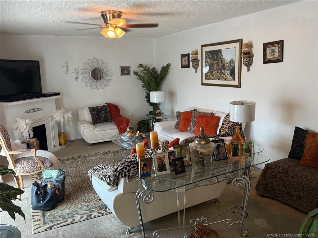 5818 Southeast Windsong Lane Stuart, FL 34997 - Photo 13 of 18 a living room with furniture fireplace and flat screen tv