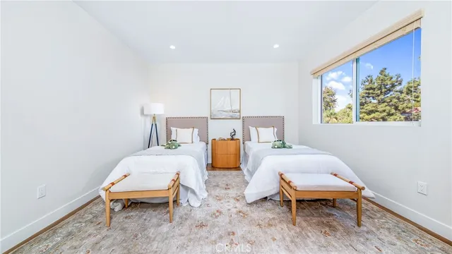 a bedroom with a bed a painting on the wall and a window