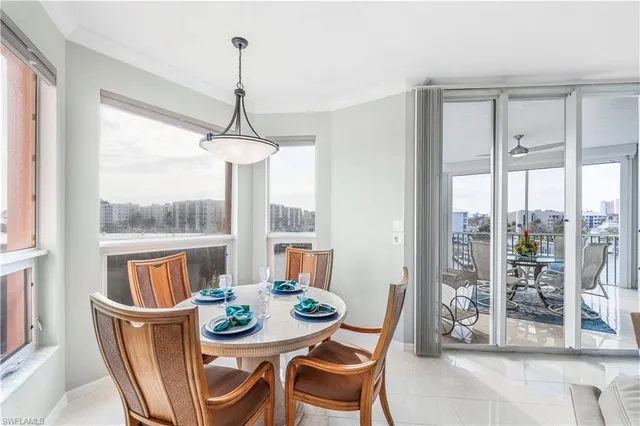 a dining room with furniture large windows and a chandelier
