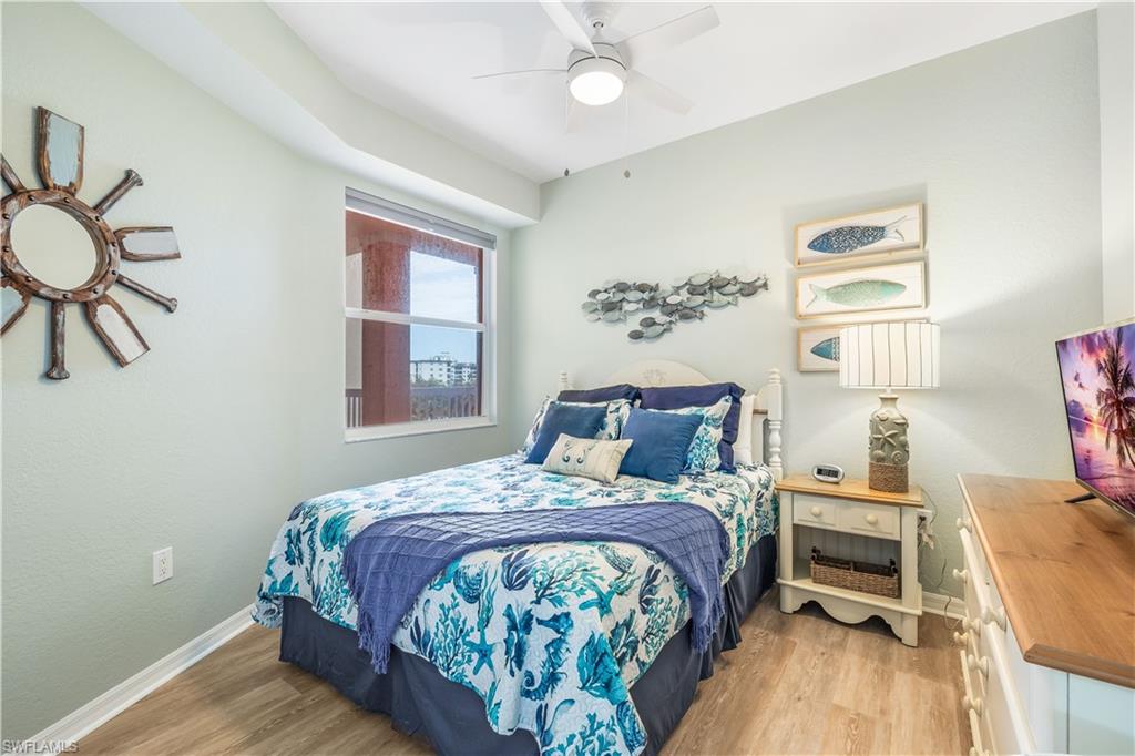 170 Lenell Road, Unit 401 Fort Myers Beach, FL 33931 - Photo 9 of 24 a bedroom with a bed and a chandelier