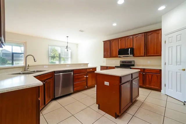 a kitchen with stainless steel appliances granite countertop a stove sink and cabinets