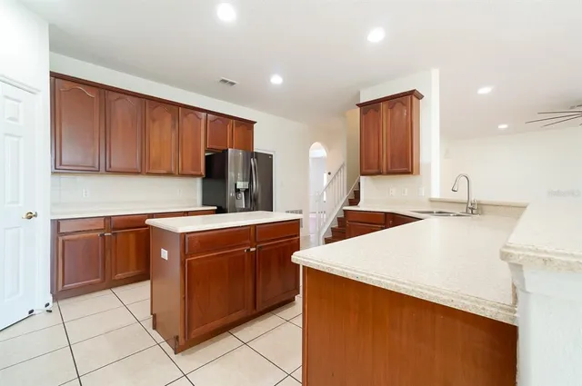 a kitchen with stainless steel appliances a stove a sink a refrigerator with white cabinets