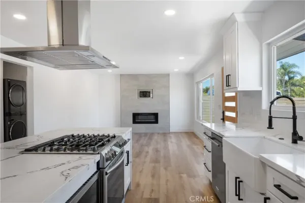 a kitchen with granite countertop a sink stove and cabinets